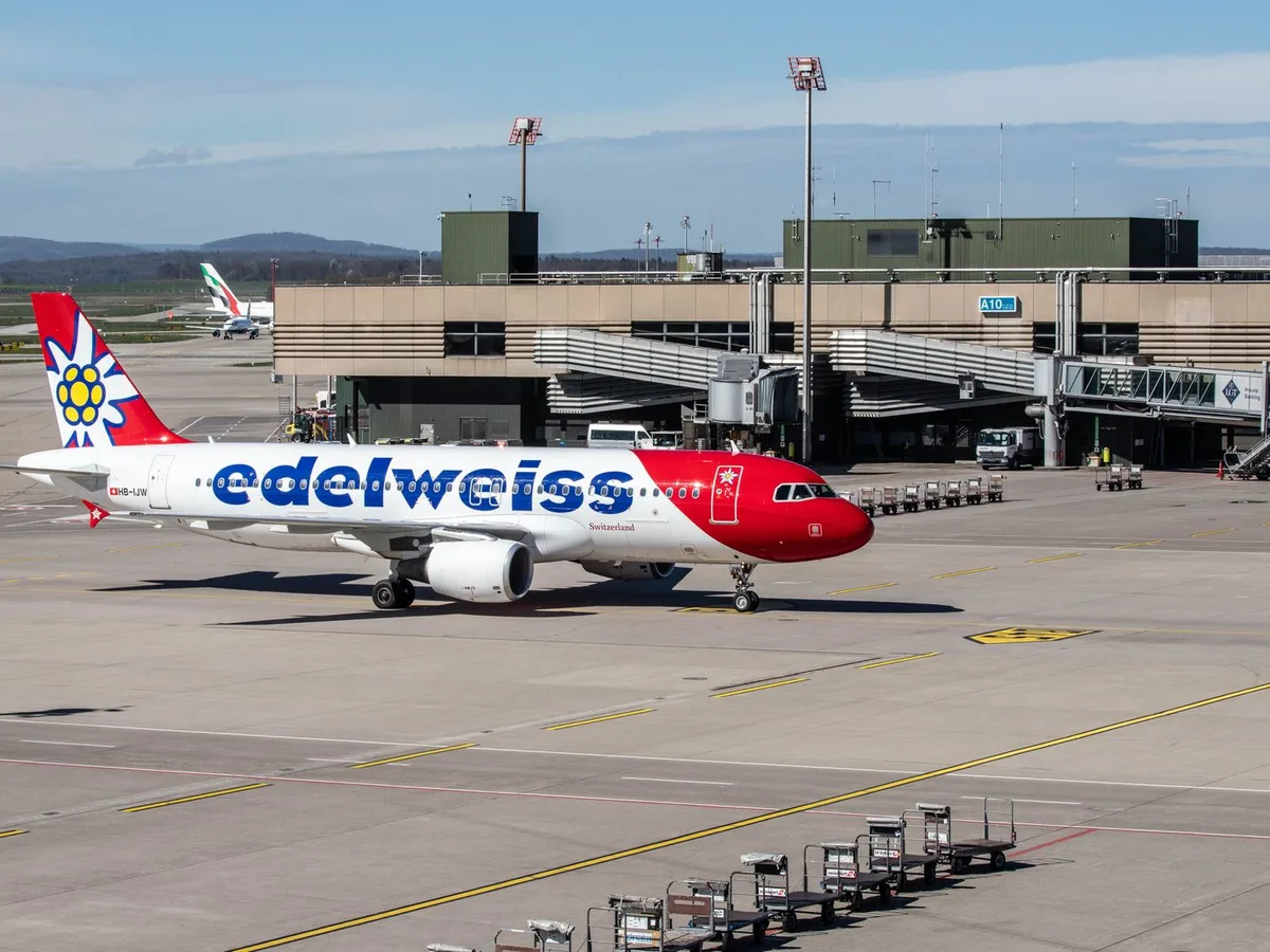 A Swiss aircraft at the terminal of Zürich Airport in Kloten, with the Glattal hills behind